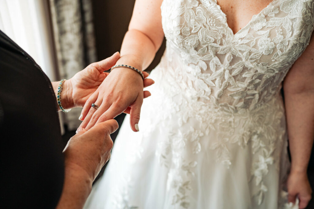 Tender moment captured as the bride's mother gently holds her daughter's hand