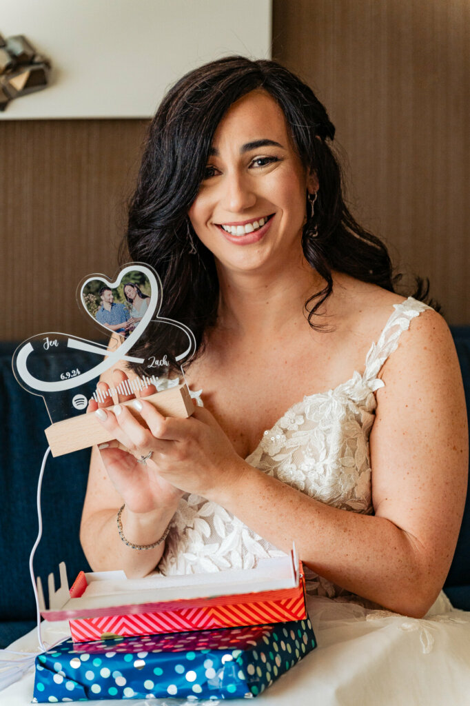 Bride beaming with happiness while holding a special gift from her groom.