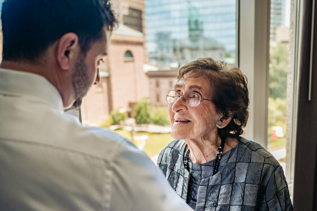 Groom's mother gazing affectionately at her son with a warm, proud smile