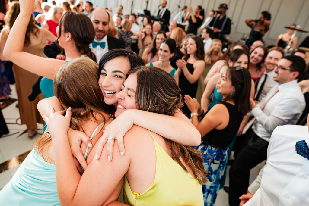 Joyful bride sharing warm embraces with her friends during the wedding reception celebration.