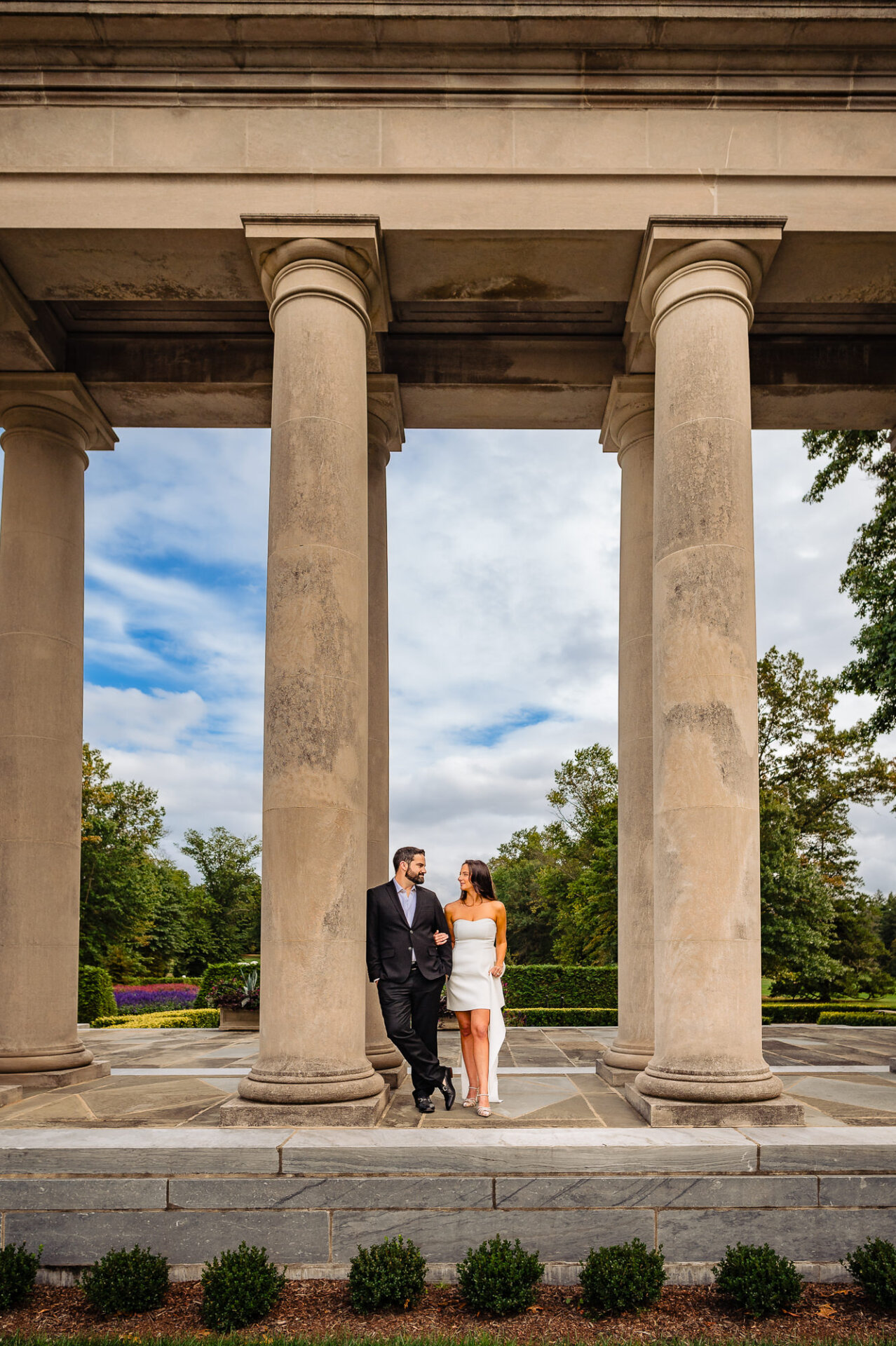 During their engagement session, the woman leans in for a kiss while they pose closely together.