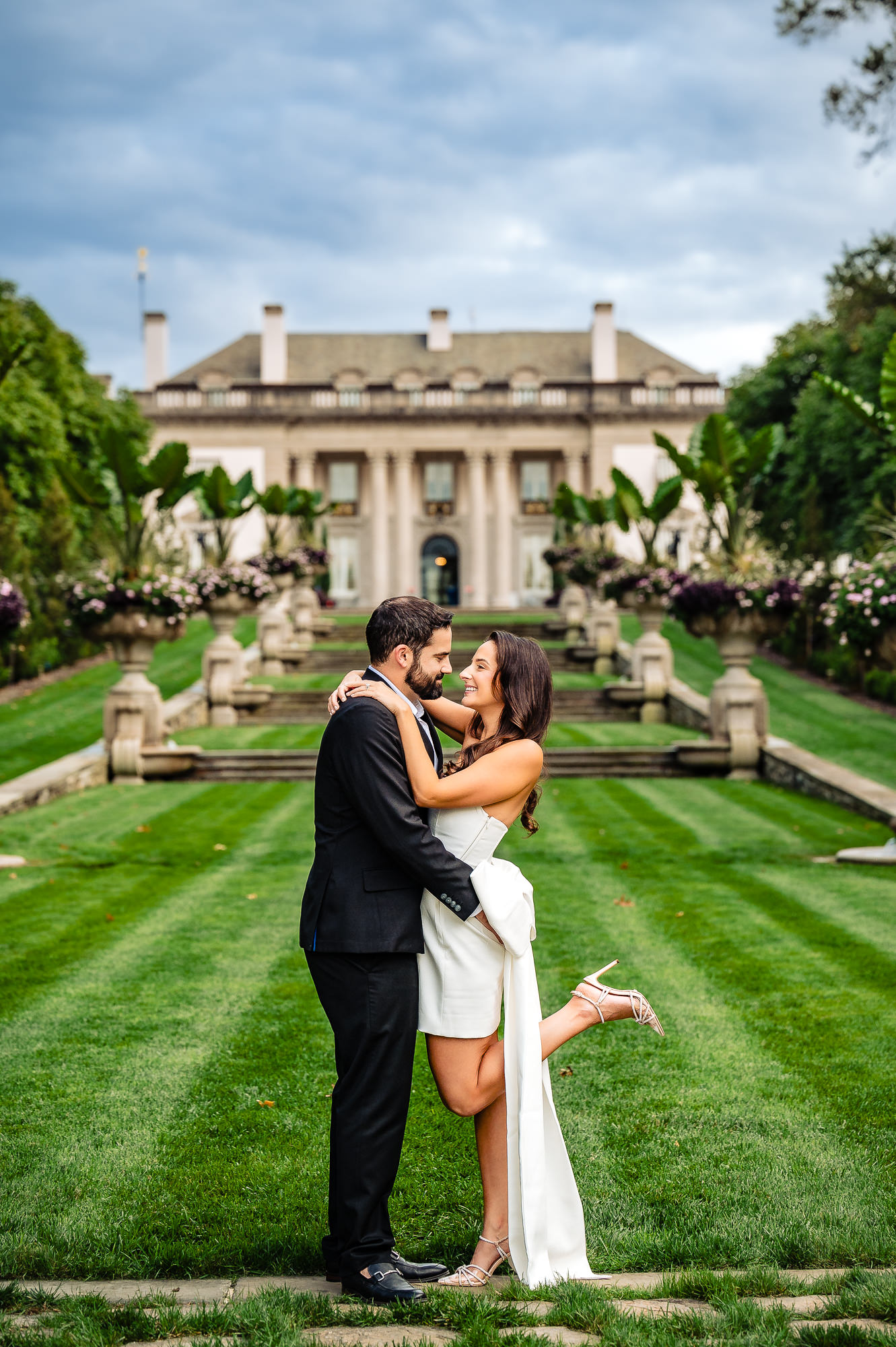 During their engagement photoshoot at Nemours Estate, the couple smiles while gazing at each other in the garden.