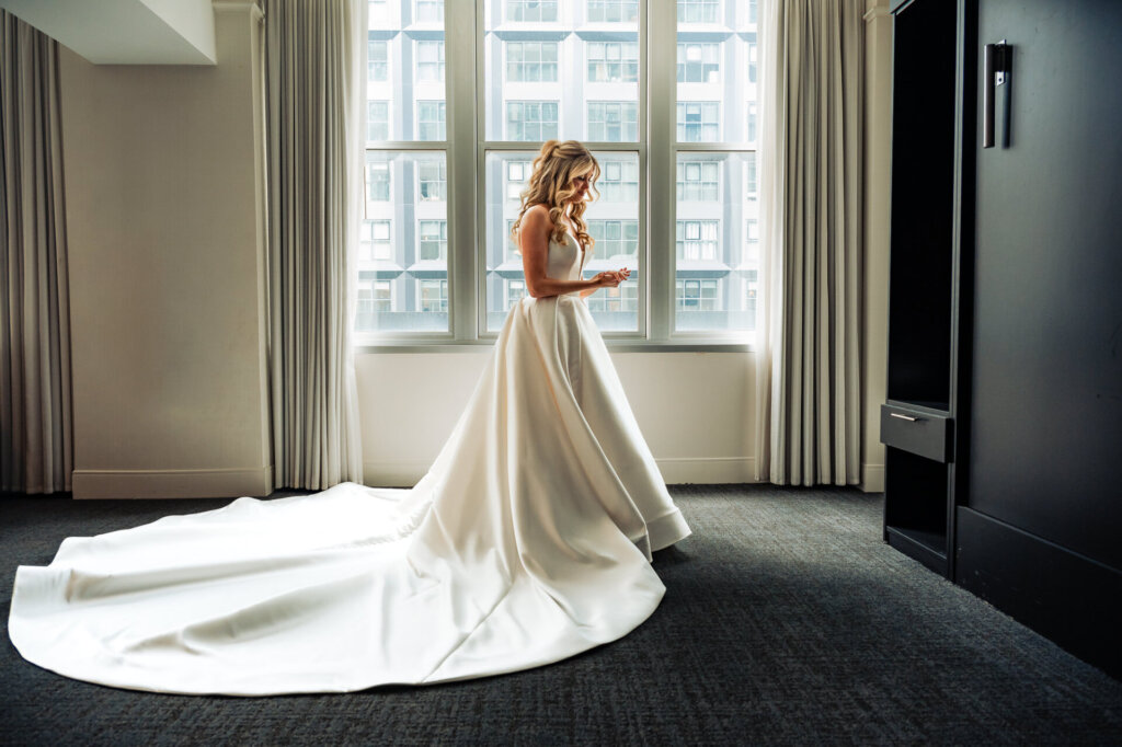 Wide side view of the bride in her wedding gown, showcasing the flowing train and elegant silhouette