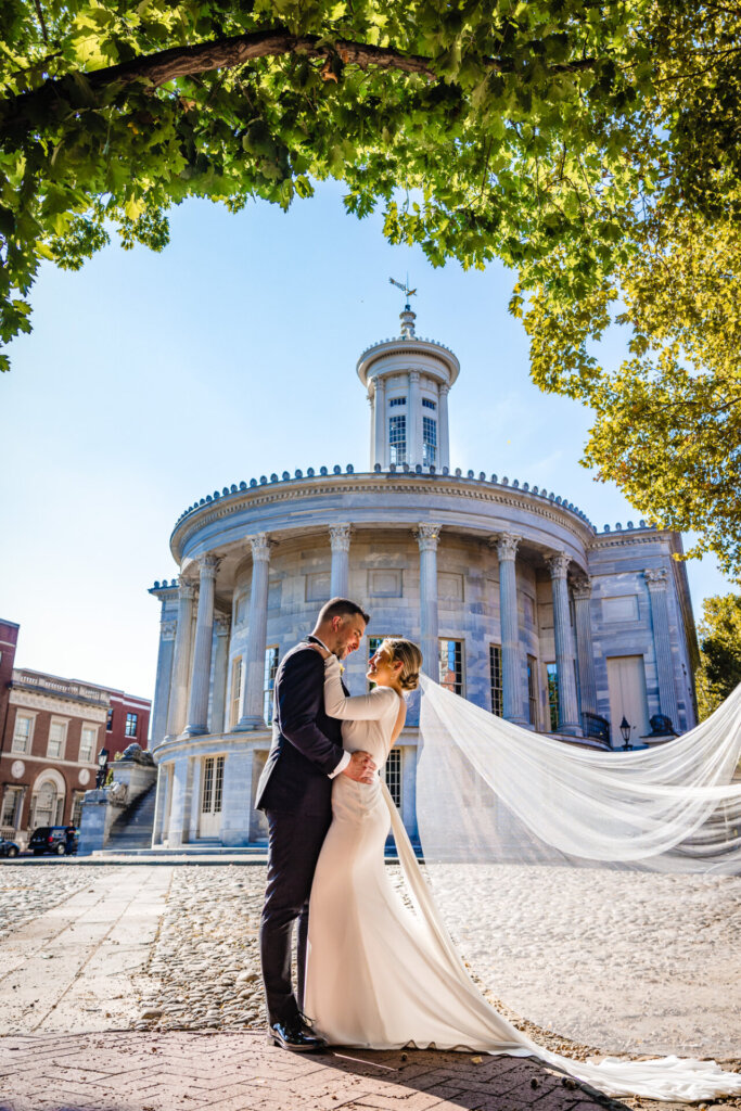 Bride and groom posing together, smiling and holding each other for their Global Dye Works Wedding