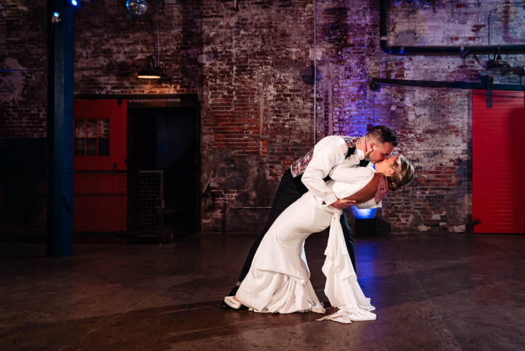 Bride and groom sharing a romantic dip on the dance floor during their wedding reception