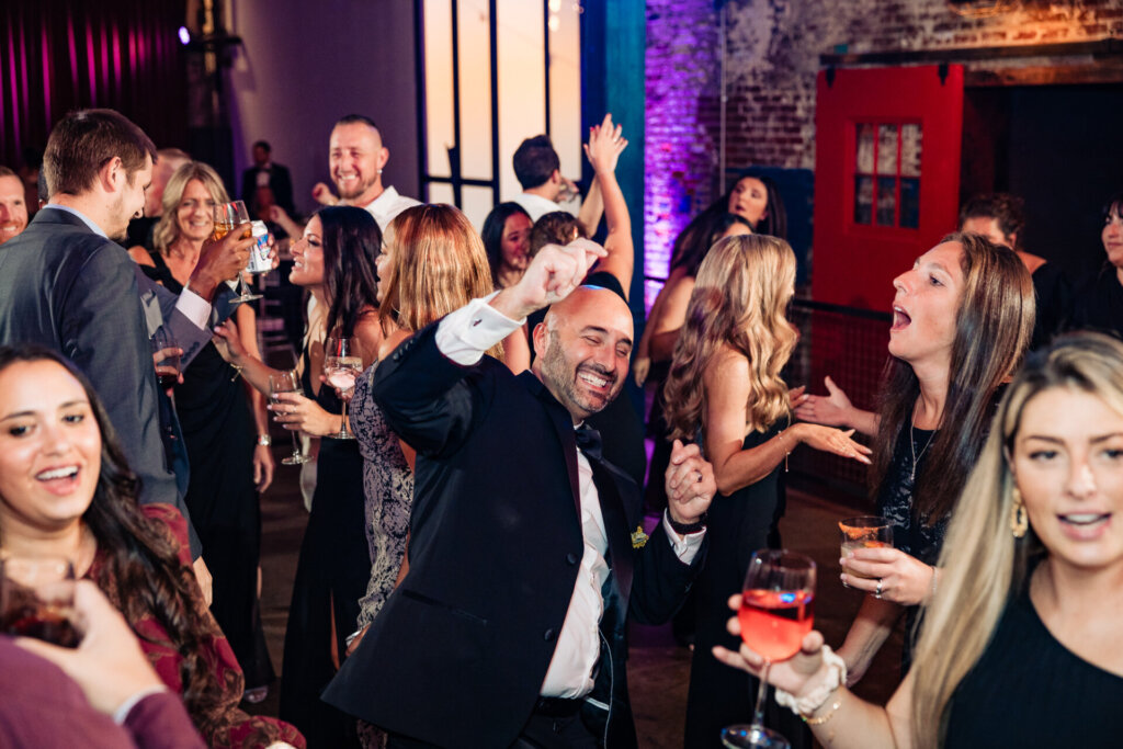 Guests dancing joyfully at the wedding reception, enjoying the lively atmosphere.
