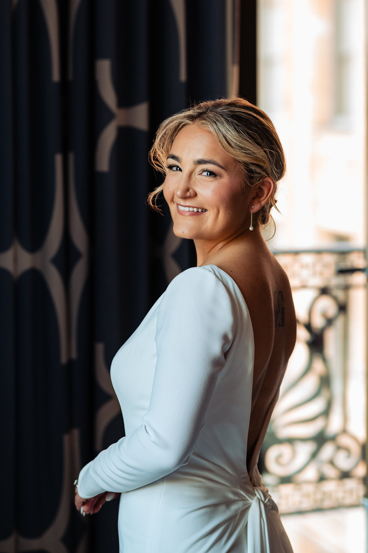 Close-up shot of the bride in her wedding gown, posed in a side view, smiling softly at the camera.