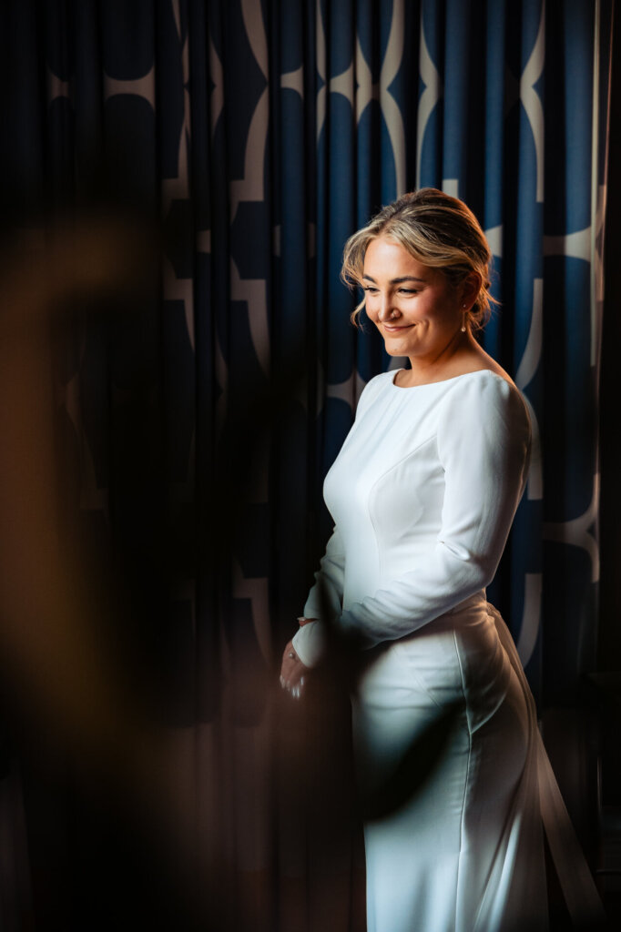 Bride smiling softly while looking down and away, radiating a serene expression