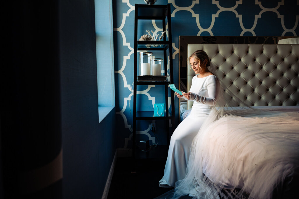 Bride sitting and reading an emotional letter written by the groom on their wedding day.