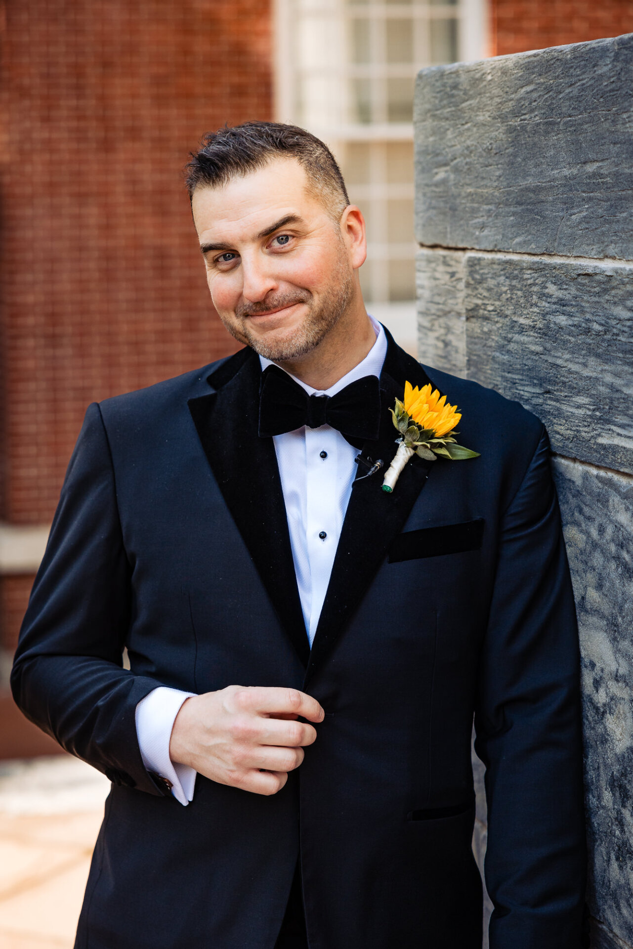 Portrait of the groom confidently posing in his wedding suit.