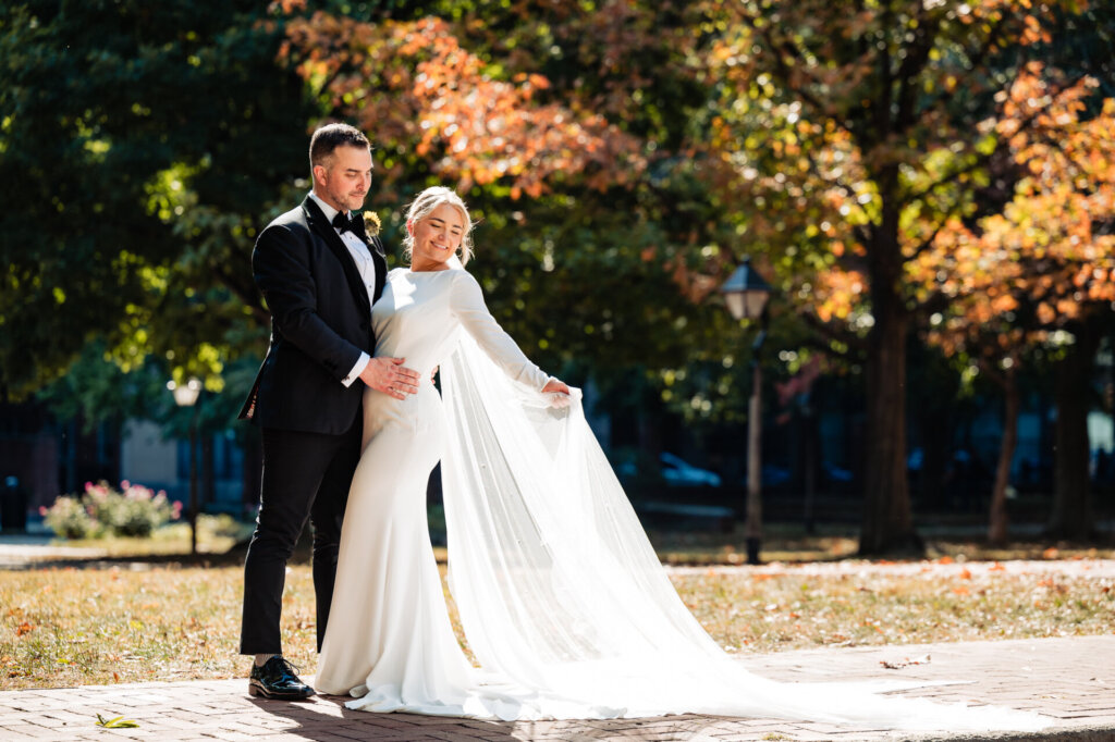 Bride and groom standing together in a natural landscape, sharing an intimate moment.