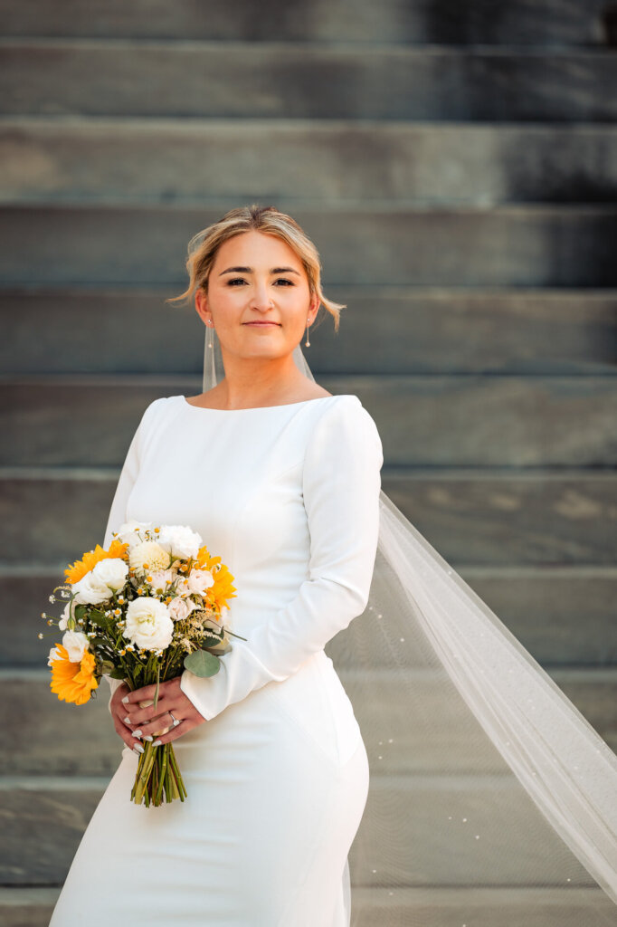 Bridal portrait of the bride standing gracefully, looking serene in her wedding gown.