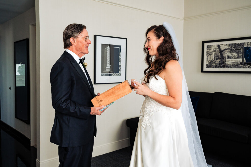 Father presenting the bride with a wooden keepsake box, sharing a sentimental moment