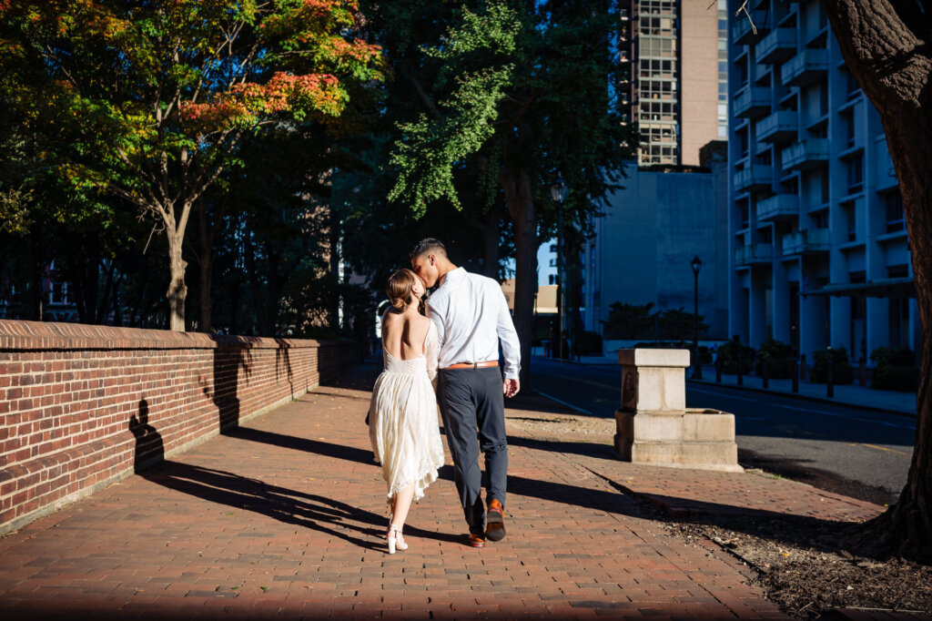 A profile shot of Batsheva and Josh walking closely through the greenery of the Old City.
