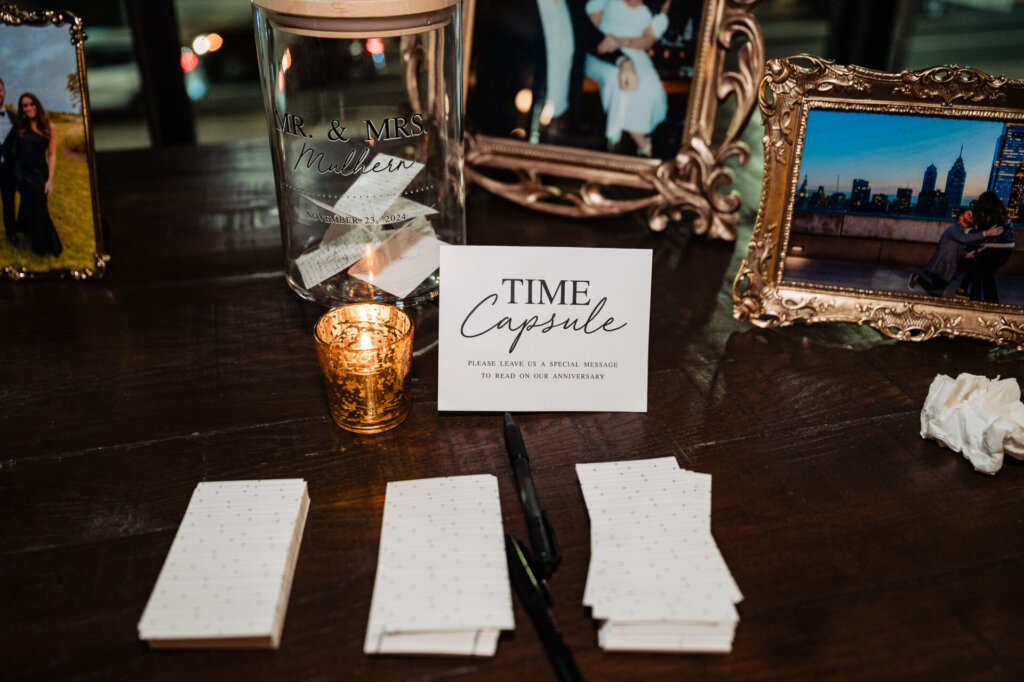 Wedding reception table with custom signage, candles, and decor, featuring a photo of the couple and an elegant rustic aesthetic