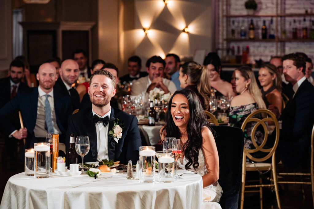 The newlyweds sharing a moment of joy during the reception, seated at their special table.