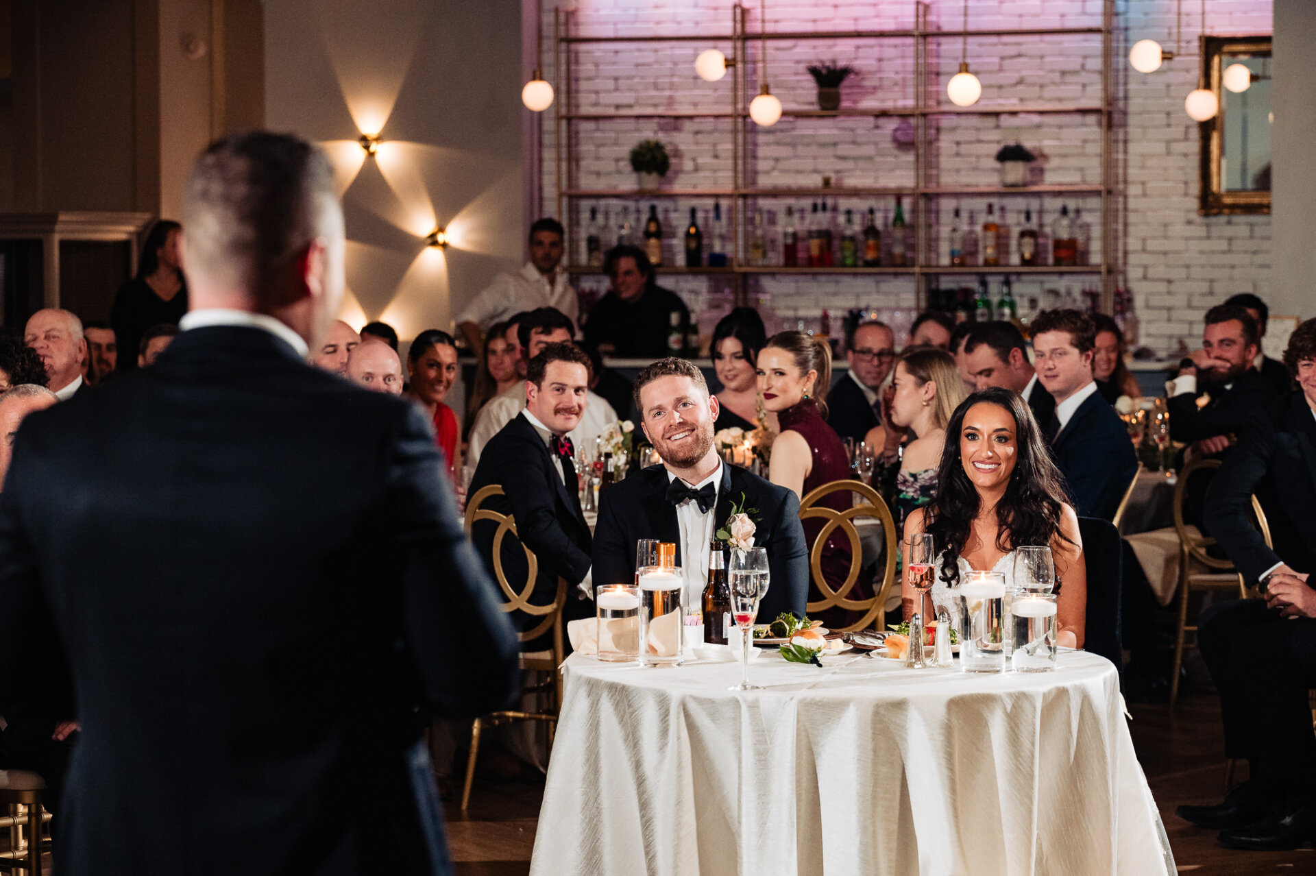 Newlyweds laughing at the speech given by a guest