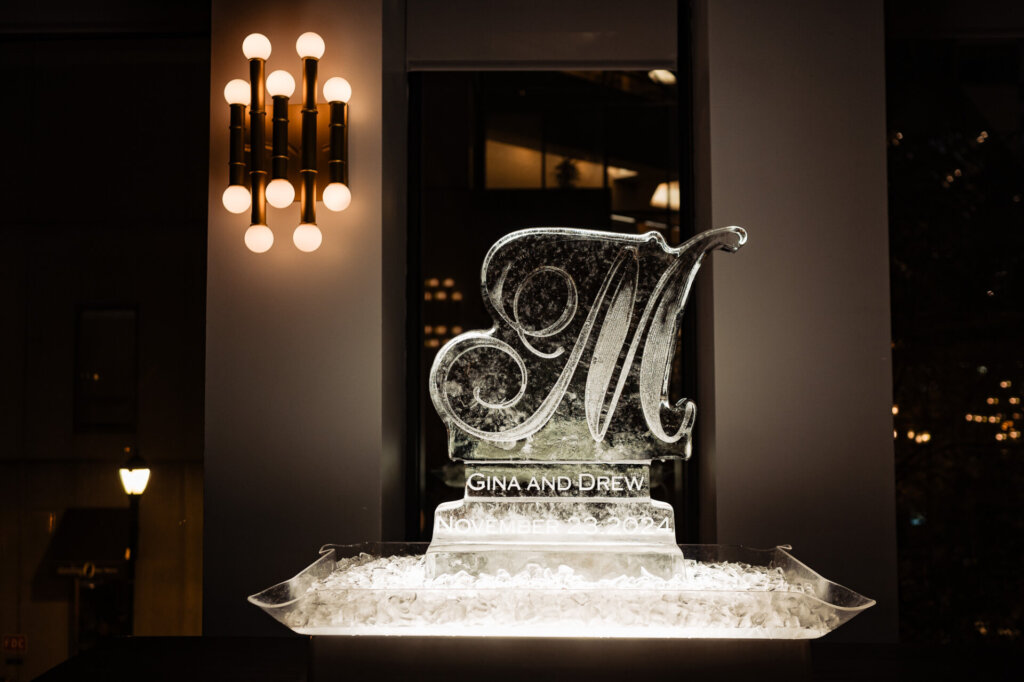A beautifully lit ice sculpture surrounded by wedding decor