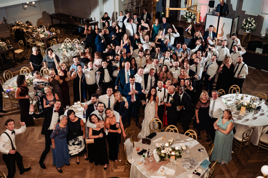 Wide-shot of everyone at the reception, smiling