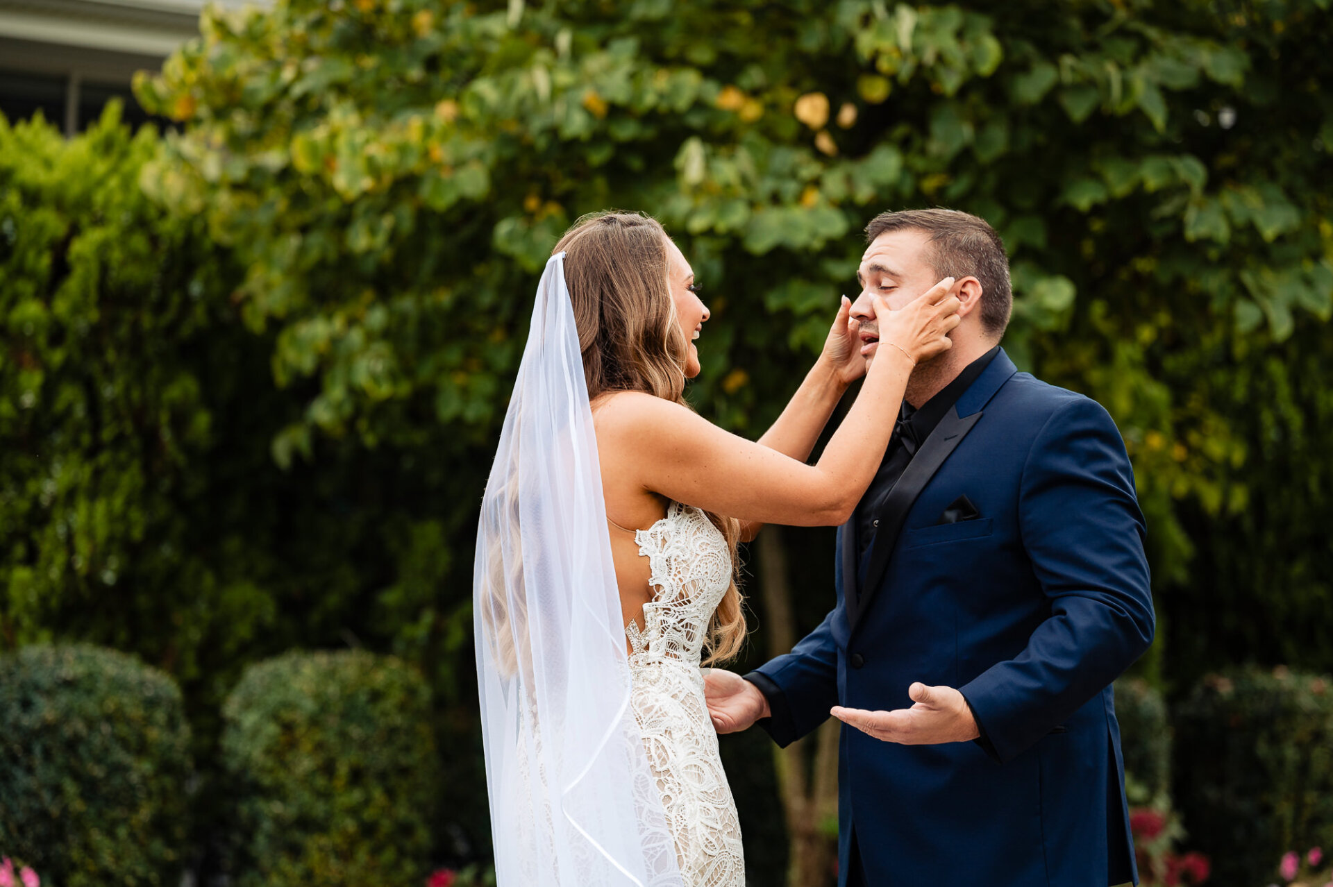 A tender moment as the bride wipes the tears of her groom with affection.
