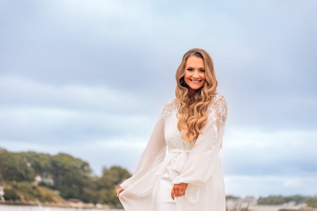 bridal portrait with soft waves cascading over her shoulders against a scenic background.