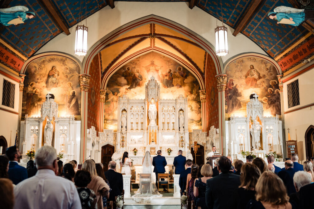 Wide-angle shot of the wedding ceremony inside the grand church – A breathtaking architectural view.