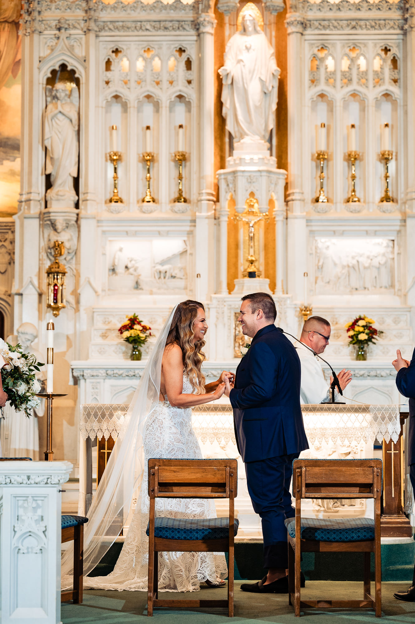 Bride and groom exchanging wedding rings in front of a golden altar – The exchange of vows captured.