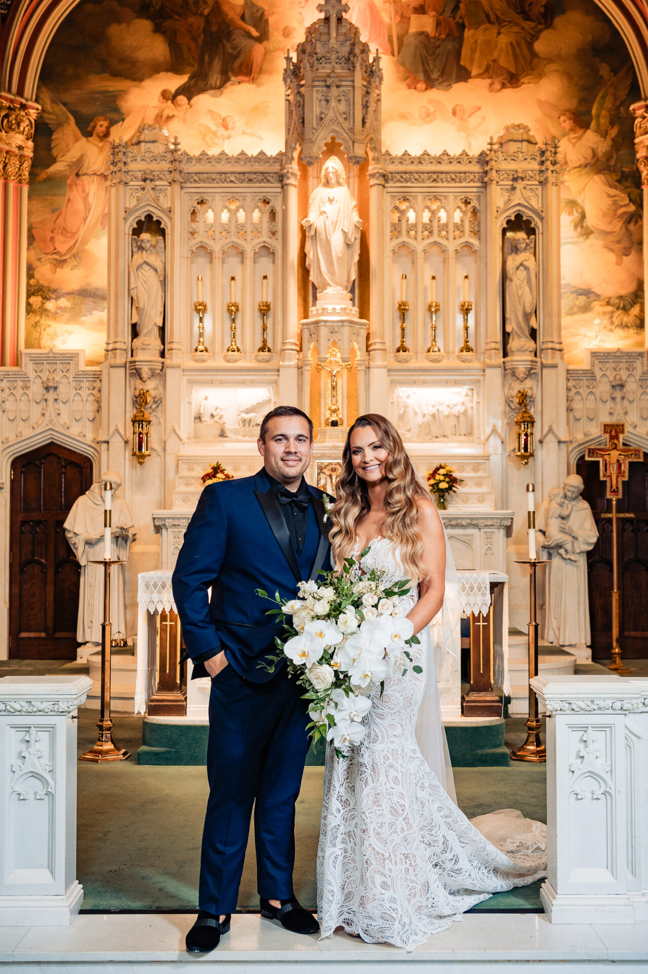 Bride and groom standing together in front of an ornate golden church backdrop – A stunning ceremony setting.