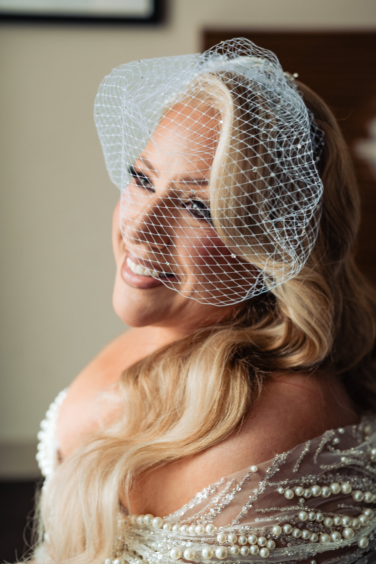Close-up of bride smiling with a vintage birdcage veil