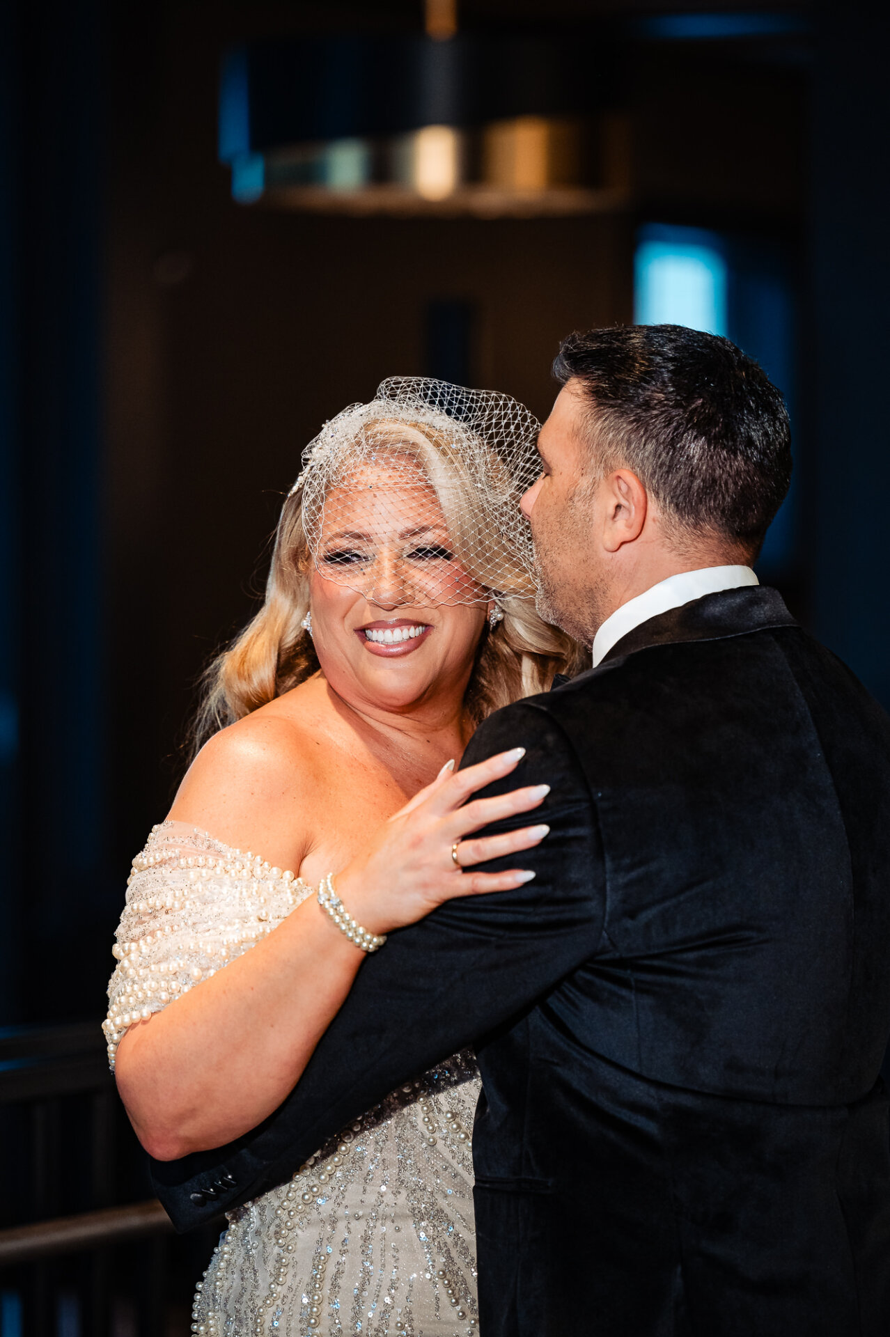 Close-up of bride and groom embracing, bride looking joyful