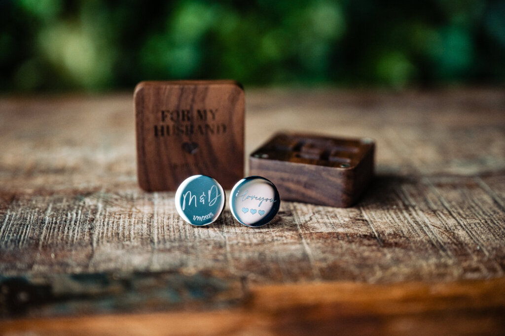 Wedding rings in an open wooden box engraved with "Til Death Do Us Part"