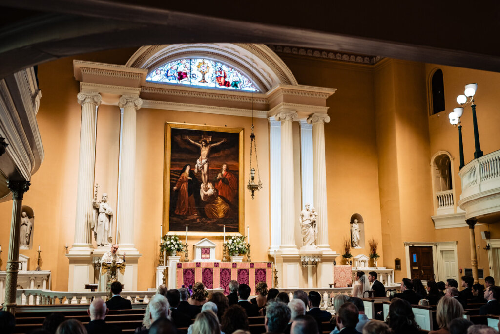 A view from the pews as guests attentively watch the couple exchange vows.