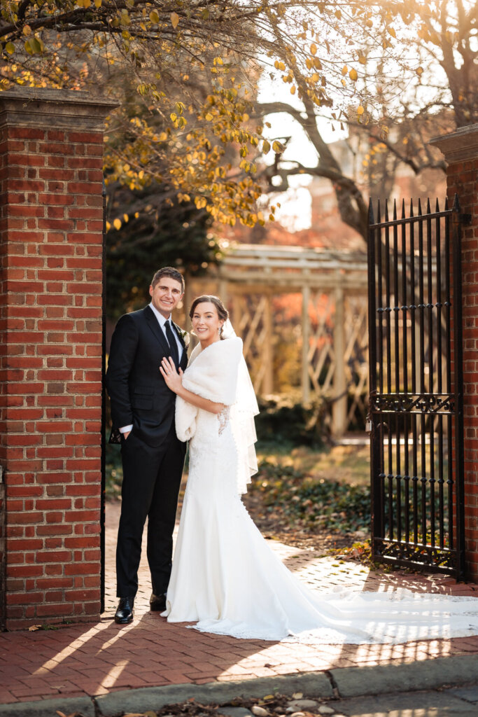 A classic portrait of the couple standing in front of a historic entrance.