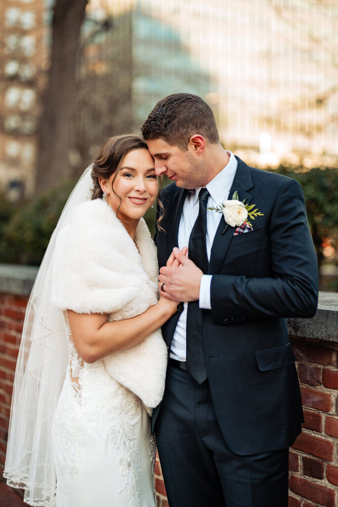 A heartfelt moment captured in front of a charming brick path with city buildings in the background.