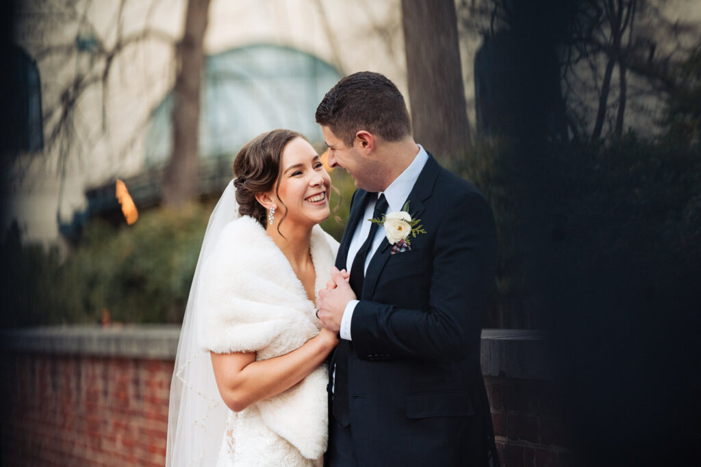 Couple smiling and laughing as they hold each other close
