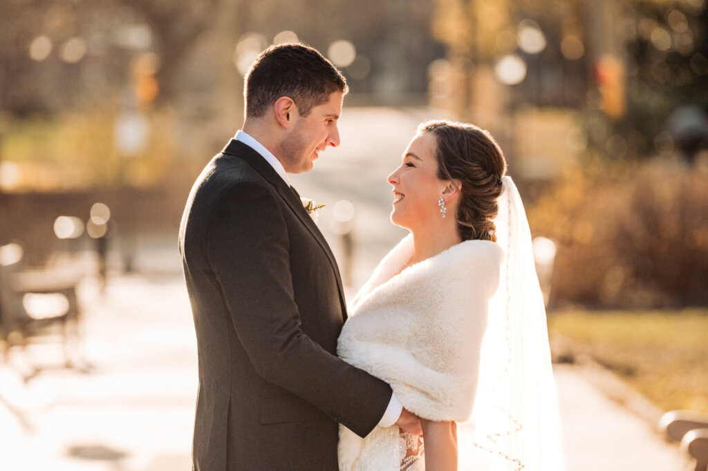A warm and intimate moment as the couple smiles at each other, bathed in soft afternoon light.