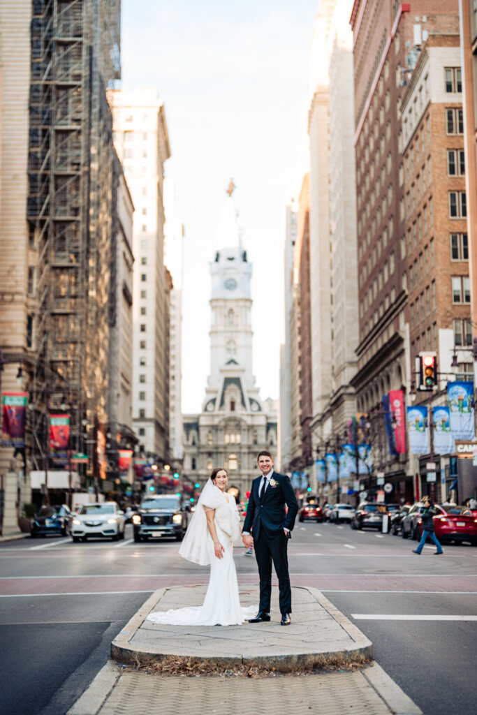 A bold urban wedding shot capturing the newlyweds in the heart of the city, with iconic buildings behind them.